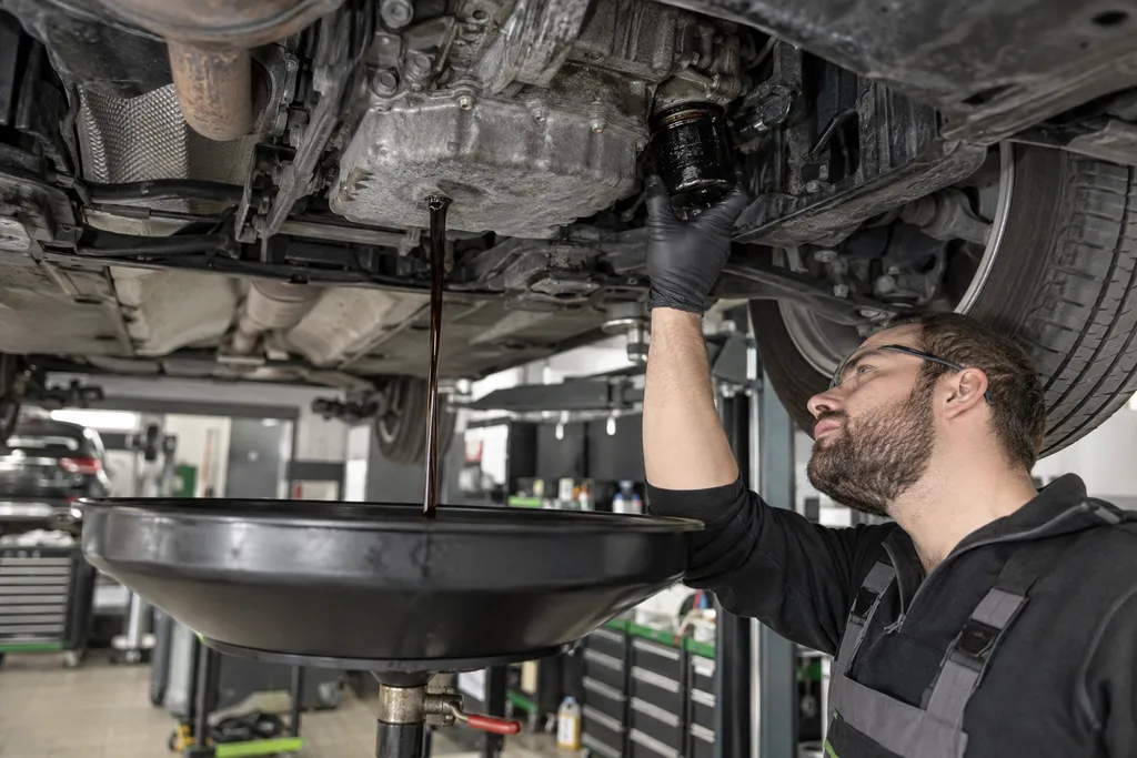 Mechanik wymieniający filtr podczas spuszczania oleju silnikowego